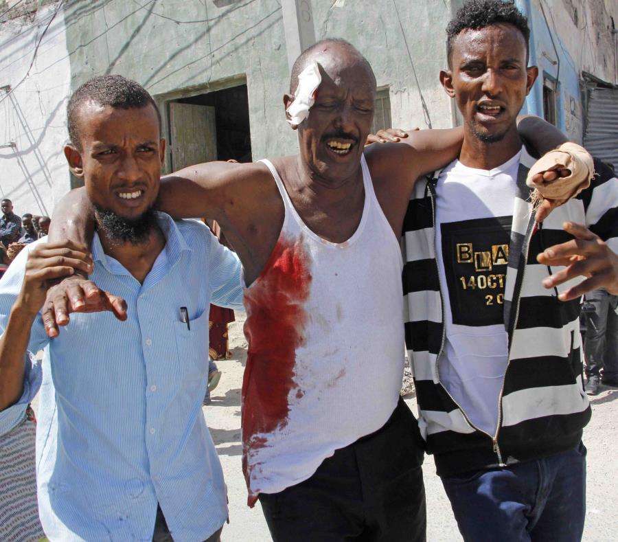 Unos jóvenes ayudan a un homre que resultó herido tras la explosión. (semisquare-x3)