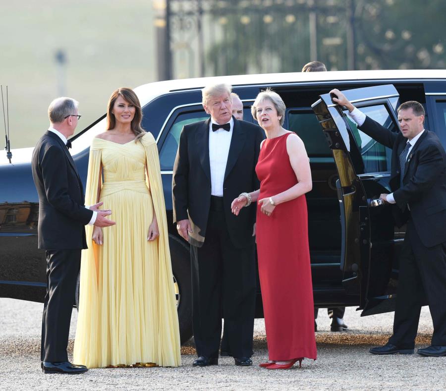 Donald Trump y su esposa, Melania, son recibidos por la primera ministra de Inglaterra, Theresa May (traje rojo). (EFE / Geoff Pugh) (semisquare-x3)