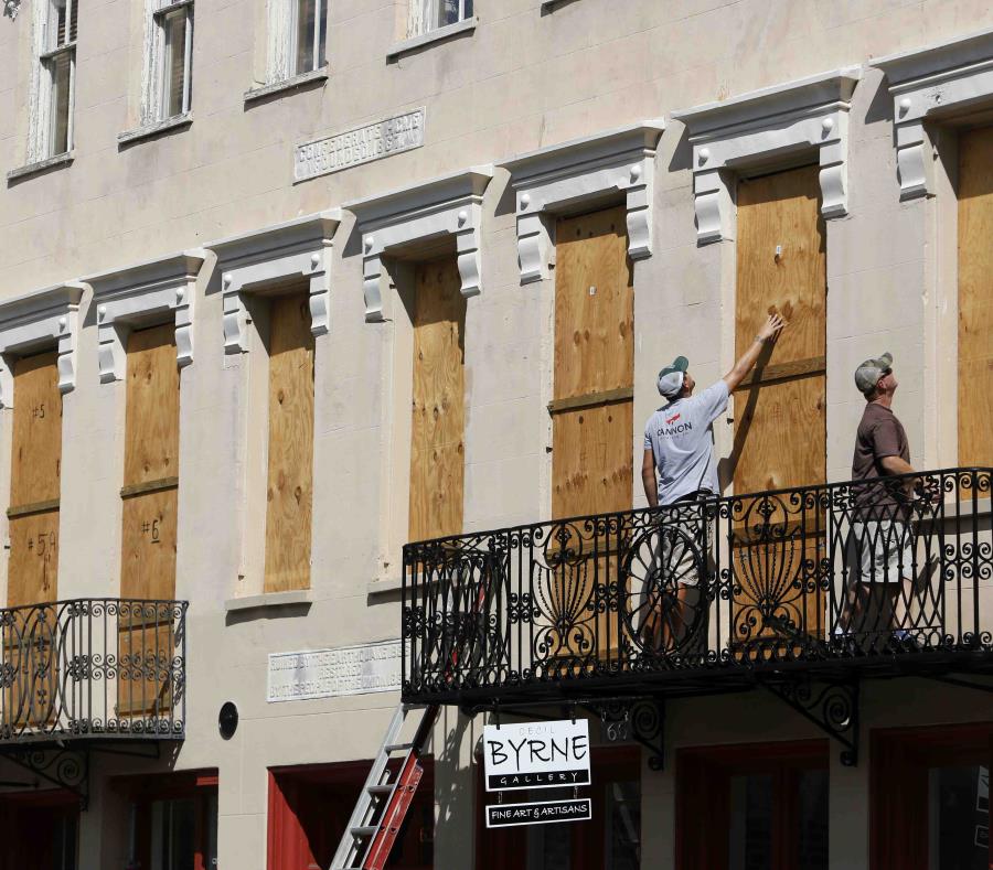 Dos personas colocan paneles de madera en Confederate House en el centro de la ciudad de Charleston, en Carolina del Sur. (AP) (semisquare-x3)