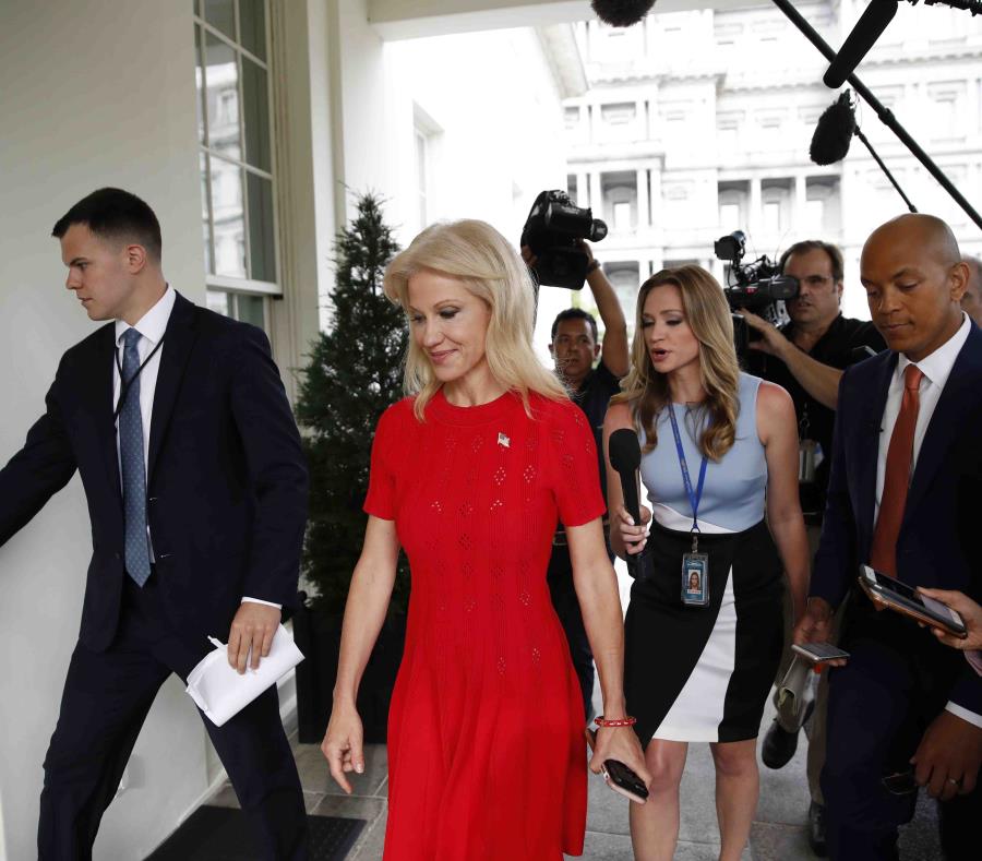 Kellyanne Conway, consejera del presidente Donald Trump, (traje rojo) va camino a una reunión con el primer mandatario estadounidense. (AP / Alex Brandon) (semisquare-x3)