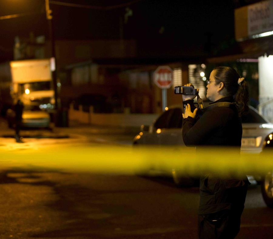 Una agente de la Policía graba la escena de un crimen. (GFR Media) (semisquare-x3)