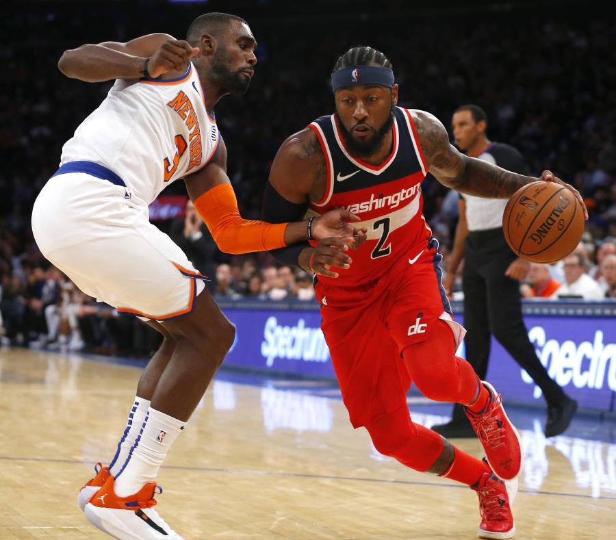 Tim Hardaway, Jr., intenta defender al armador de los Wizards de Washington, John Wall (con el balón). (AP / Noah K. Murray) (semisquare-x3)