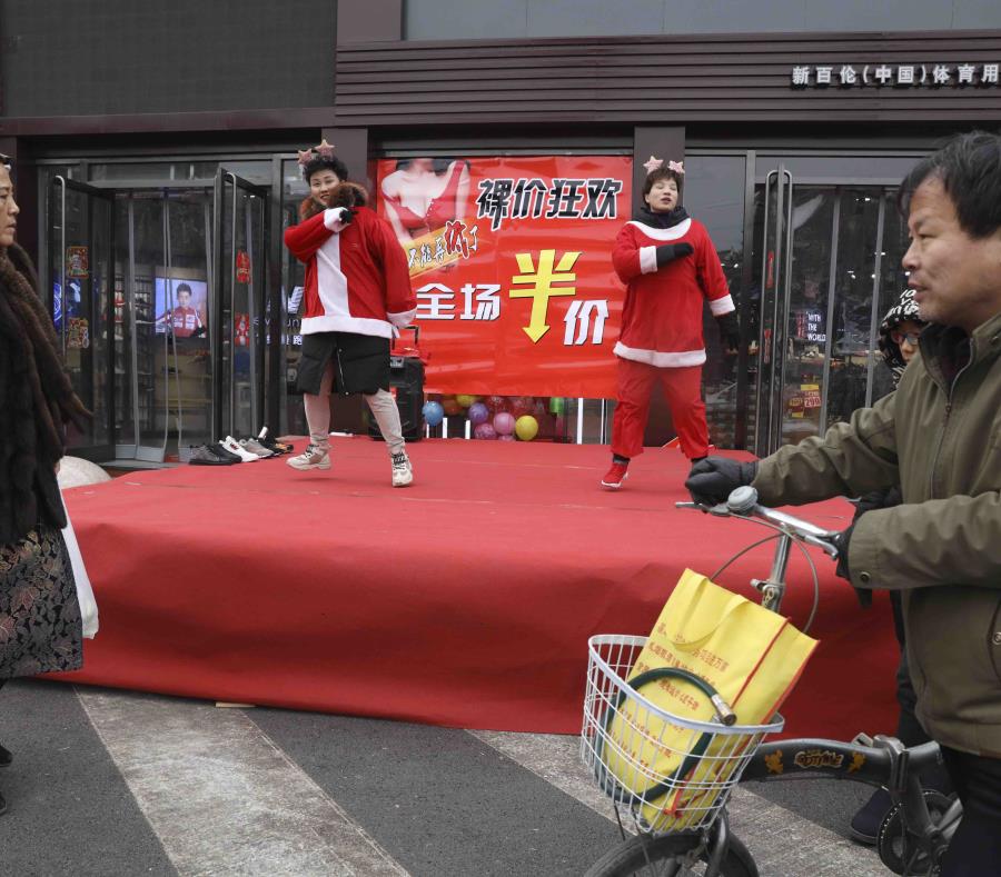 Esta foto del sábado 22 de diciembre del 2018, muestra a vendedores de una tienda con trajes de Santa Claus bailando para atraer clientes, en Zhangjiakou, provincia de Hebei, al norte de China. (AP) (semisquare-x3)