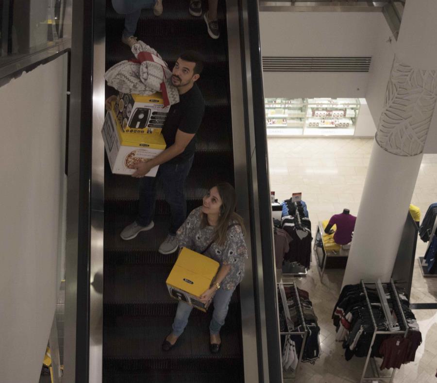 Dos personas bajan las escaleras de Macy's con varios Air Fryer. (semisquare-x3)