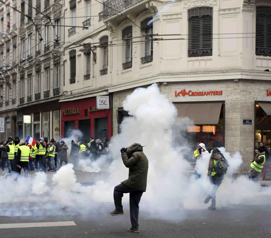 Manifestantes protestan en medio de gases lacrimógenos en Lyon, centro de Francia, el sábado 15 de diciembre de 2018. (AP) (semisquare-x3)