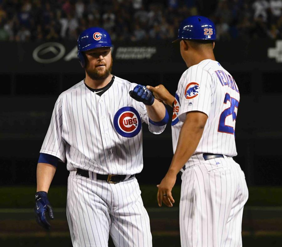 Jon Lester choca puños con el coach de primera base Will Venable después de pegar un sencillo de dos carreras. (AP) (semisquare-x3)